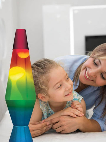 A child looking at a many colored lamp